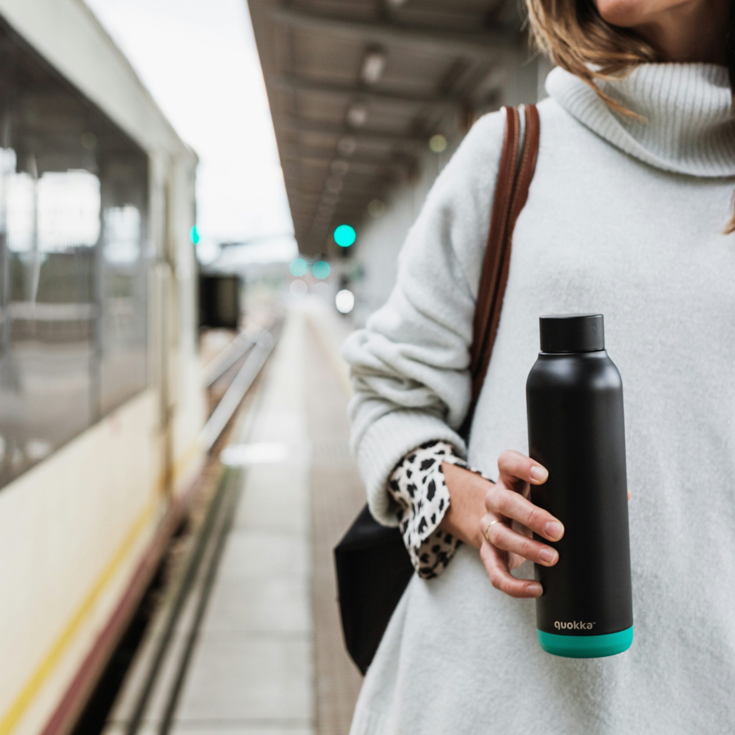 Woman travelling holding refillable water bottle